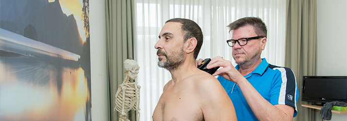 Chiropractor Amsterdam NH J.G. Drewry Examining Patients Shoulders